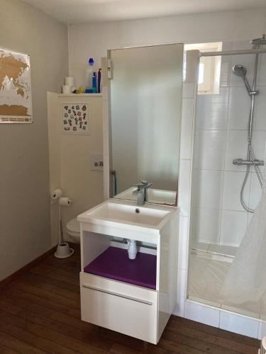a white bathroom with a sink and a shower at Appartement centre in Quiberon