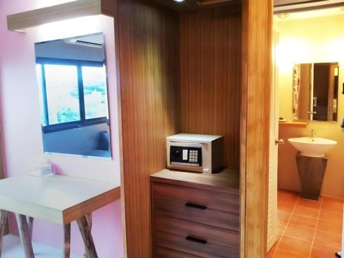 une salle de bain avec un micro-ondes sur un meuble en bois dans l'établissement Klim Hotel, à Buriram