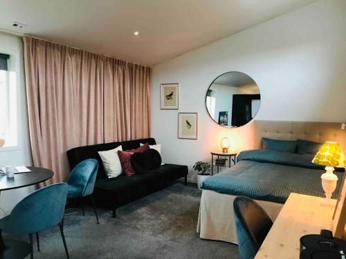 a bedroom with a bed and a couch and a mirror at Private apartment with hotel feeling in Hudiksvall