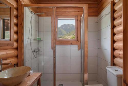 a bathroom with a shower and a sink and a window at Chalet Styga Kalavrita in Kalavrita