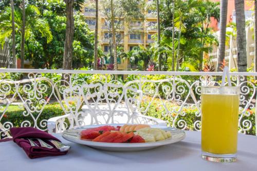 a plate of fruit on a table with a glass of orange juice at Posada de Tampico in Tampico