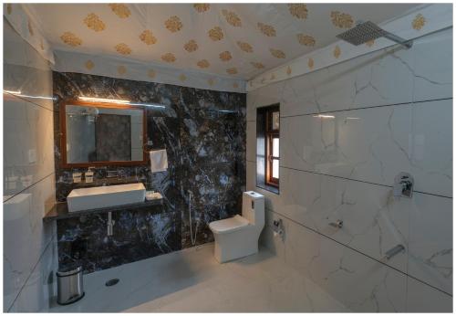 een badkamer met een toilet, een wastafel en een spiegel bij Upvan Jawai - Unit of Dev Group in Bāli