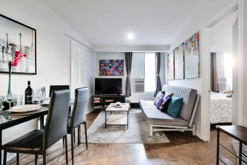 a living room with a table and a dining room at 250 METERS to METRO BERRI UQAM - Spacious fully equipped APARTMENTS - 1 FREE PARKING per unit - in-unit Washer & Dryer - fully stocked KITCHEN - WORKSPACE PROVIDED - FAST WIFI - 5 minute walk to the FAMOUS ST CATHERINE & ST DENIS STREET in Montreal