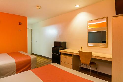 a room with two beds and a desk with a mirror at Motel 6-Sycamore, IL in Sycamore