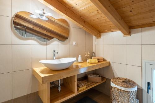 a bathroom with a bowl sink on a wooden counter at Casa Sorgente in Ágioi Doúloi