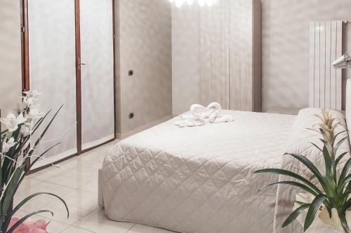 a bedroom with a white bed with a plant at La Tarantola in Vermezzo
