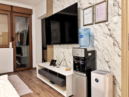 una stanza con un frigorifero e un tavolo bianco di Apartman Una a Plužine