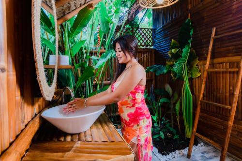 a woman standing in a bath tub in a room at Tongo Hill Cottages in Moalboal