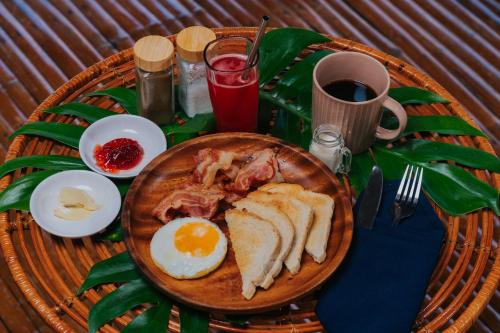a plate of breakfast food with an egg and bacon at Tongo Hill Cottages in Moalboal