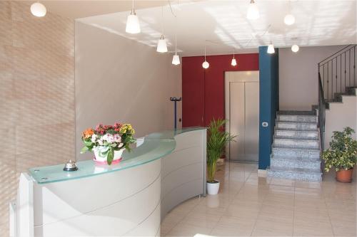 a lobby with a vase of flowers on a counter at La Tarantola in Vermezzo