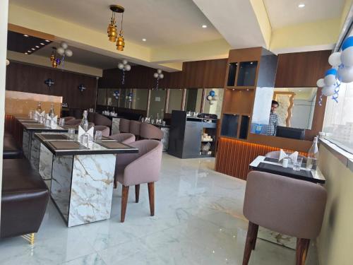a restaurant with tables and chairs and a woman in the mirror at Hotel Diamond Crest, Patna in Lok Nayak Jayaprakash Airport