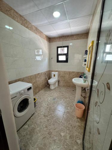 un bagno con lavatrice e WC di Lovely studio inside Abu Dhabi a Abu Dhabi