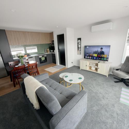 a living room with a gray couch and a table at Modern Heritage 2BR Home in Christchurch