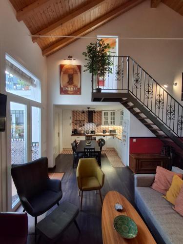 een woonkamer met een trap en een tafel bij Casa Valparaíso Málaga - 350m from beach in Málaga