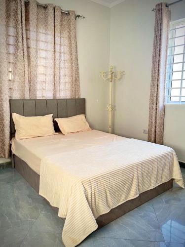 een slaapkamer met een groot bed met een kruis aan de muur bij home in Nungwi