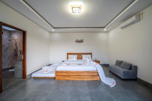 a bedroom with a large bed and a couch at Galatia Villa in Bukti
