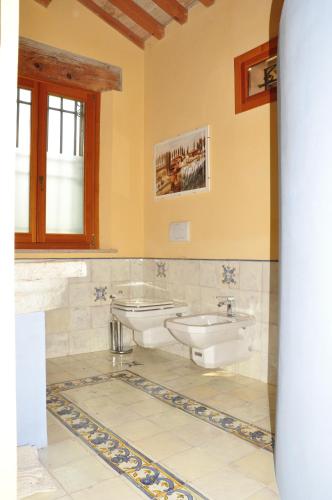 PortomaggioreにあるLa Casina sul Sandaloのバスルーム(洗面台2つ、トイレ2つ付)