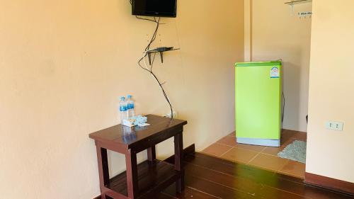 a room with a green refrigerator and a table at Yada Resort Koh Yao Noi in Ko Yao Noi