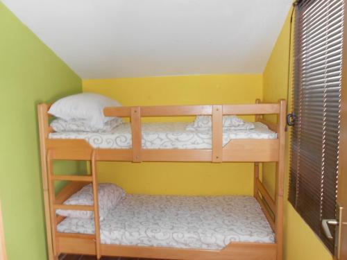 2 Etagenbetten in einem Zimmer mit gelben Wänden in der Unterkunft Apartments Mudrić in Herceg-Novi