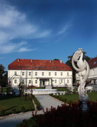 a large white building with a statue in front of it at Hotel Nysa in Nysa