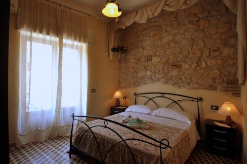 a bedroom with a bed and a stone wall at B&B Maison Civico 13 in Ausonia