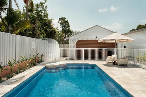 a swimming pool in a backyard with a fence at Catalina Motel Lake Macquarie in Toronto