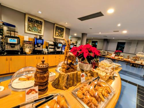 a cafeteria with a buffet of food on a table at Hotel Express Aosta East in Aosta