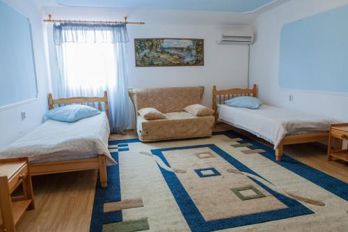 スタヴロポリにあるHotel VITAのベッド2台、椅子、ラグが備わる客室です。