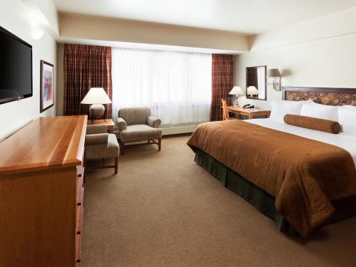 a hotel room with a large bed and a television at Alta's Rustler Lodge in Alta