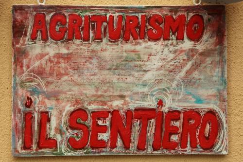 an old red sign hanging on a wall at Il Sentiero in Acquapendente