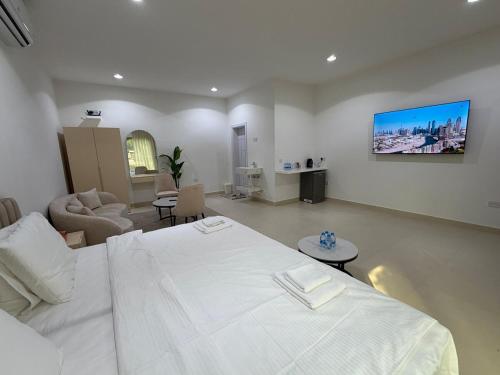 a bedroom with a white bed and a living room at Sky5 Apartment in Hatta