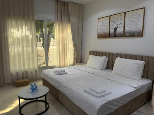 een slaapkamer met een bed met een tafel en een raam bij Sky5 Apartment in Hatta