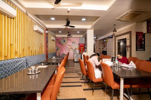 2 personnes assises à table dans un restaurant dans l'établissement Namaste Khatu Shyam, à Khātu