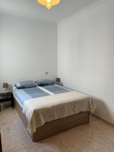 a bedroom with a bed with blue pillows on it at MarMontaña in Arinaga