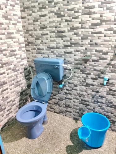 a bathroom with a blue toilet in a brick wall at Camp and kaya king for Foreign travelers only in Alleppey