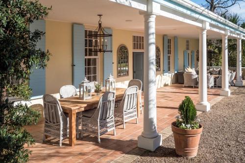 an outdoor patio with a wooden table and chairs at Auberge Clermont in Franschhoek