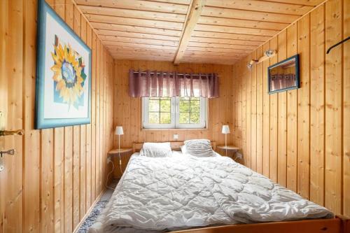 een slaapkamer met een bed in een houten kamer bij VGO786-Hacksvik-Hacksvik-1 in Bygärde