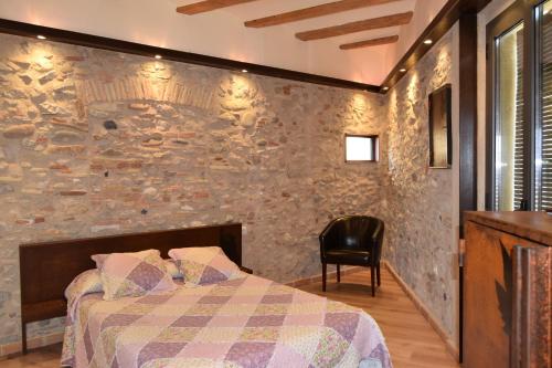 a bedroom with a bed and a stone wall at Casa Cundaro in Girona