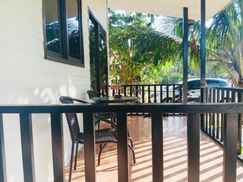 a balcony with a table and chairs on a porch at First Light Garden House in Koh Phangan