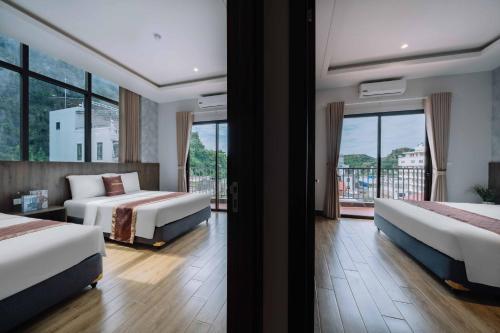 een hotelkamer met twee bedden en een balkon bij Véra Stay - Cat Ba in Cat Ba