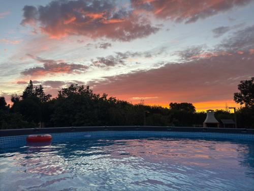 a swimming pool with a sunset in the background at Quinta da Foz - Vivenda Amélia in Foz