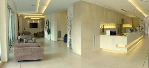 a lobby with a couch and a bar in a building at Baldinini Hotel in Rimini