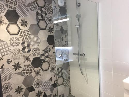 a bathroom with a shower with a glass door at Le Clos du miroir in Courset