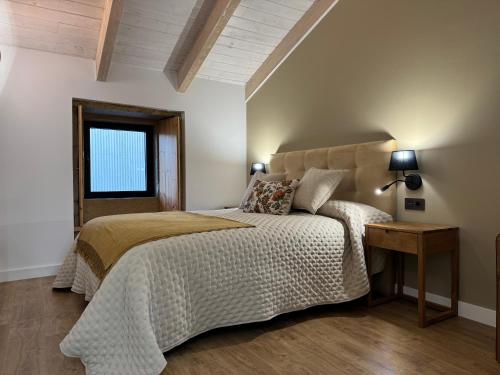 a bedroom with a bed and a table and a window at Casa Gafura in Noya