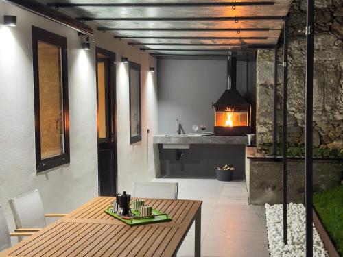a dining room with a wooden table and a fireplace at Casa Gafura in Noya
