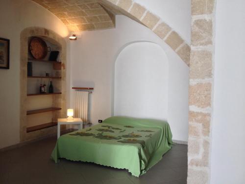 ポリニャーノ・ア・マーレにあるDimora Tarantiniのベッドルーム(緑のベッド1台、テーブル付)