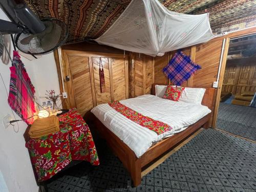 a small bedroom with a bed and a table at Đoàn Kết Homestay in Dồng Văn