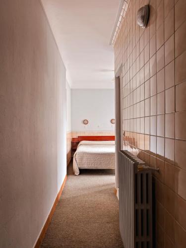 a small room with a bed in a room at Hôtel de la Comète in Paris