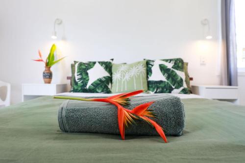 ein Bett mit einem Kissen mit einer Feder darauf in der Unterkunft The Green House in Matavera