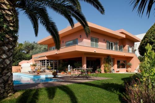 a house with a swimming pool in front of it at Slow living beautiful villa in Rafina
